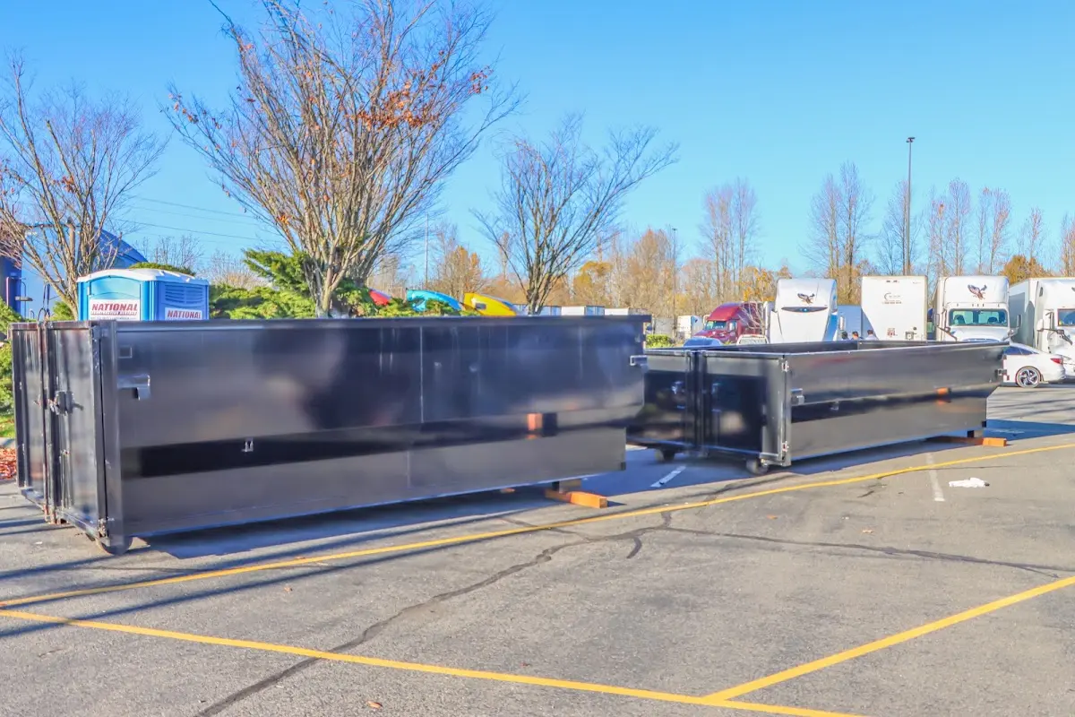 Professional dumpster rental service with roll-off container on residential driveway in Belmont